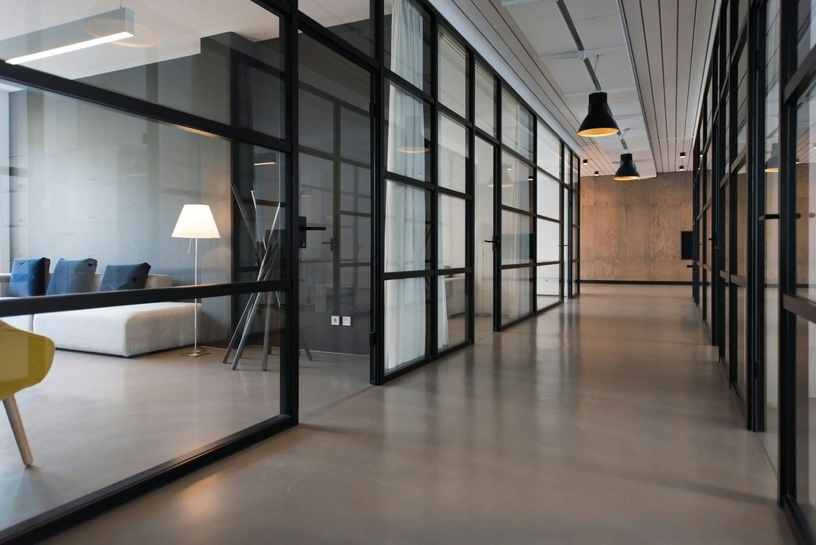 A quiet office corridor with glass walls